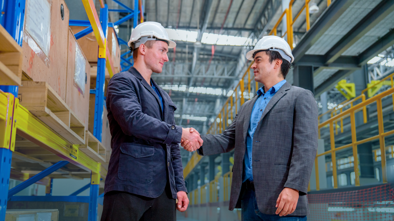 Feature image Shoplogix blog post about manufacturing as a service with two men on the shop floor shaking hands