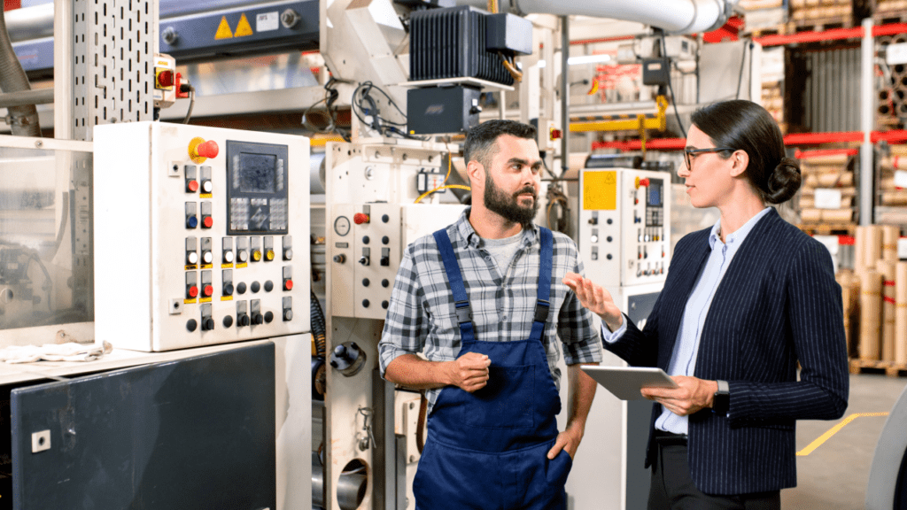 Young factory engineer in workwear standing by processing line