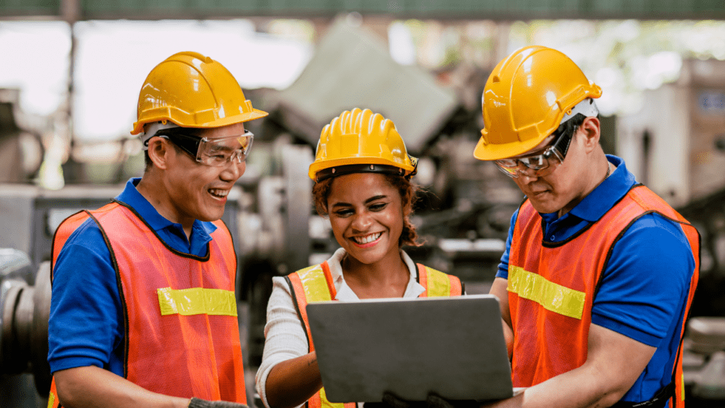 Multiracial engineer workers team in safety uniforms working on a computer