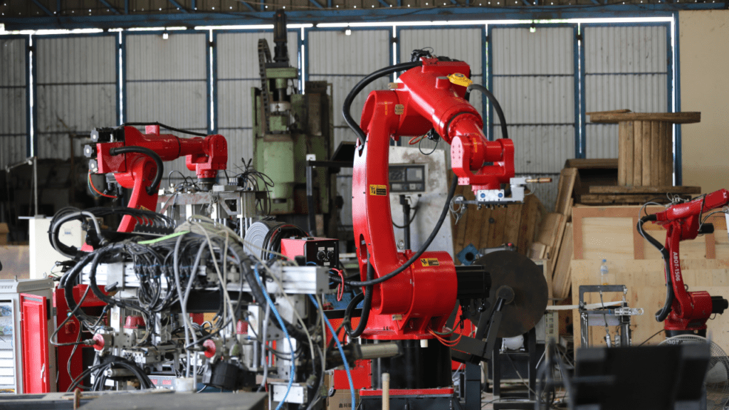 Robotics arm in the metal factory plant its performing routine servicing of the welding robotics units equipment